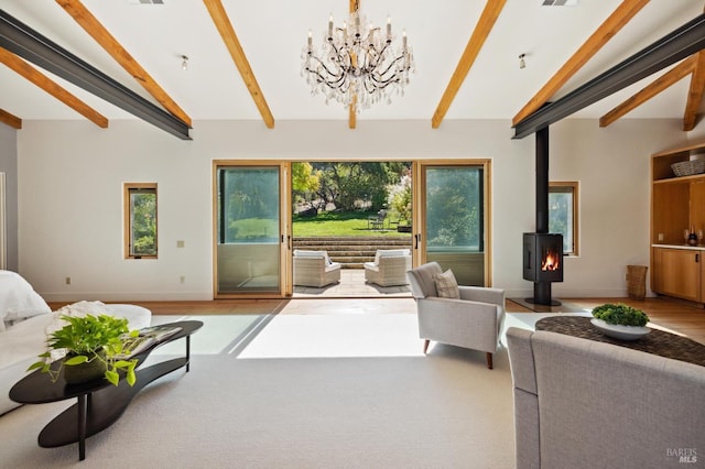 living room featuring an inviting chandelier, a wood stove, vaulted ceiling with beams, and visible vents