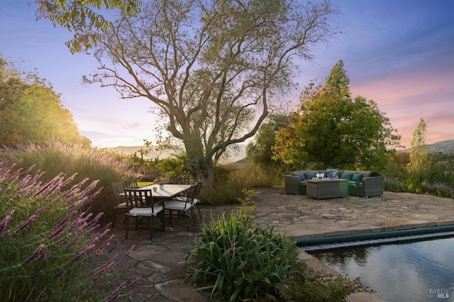 patio terrace at dusk featuring an outdoor hangout area