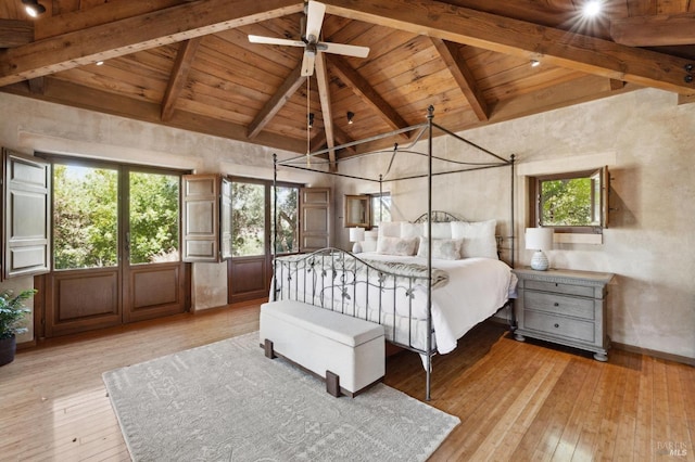 unfurnished bedroom with baseboards, light wood finished floors, high vaulted ceiling, wood ceiling, and beamed ceiling