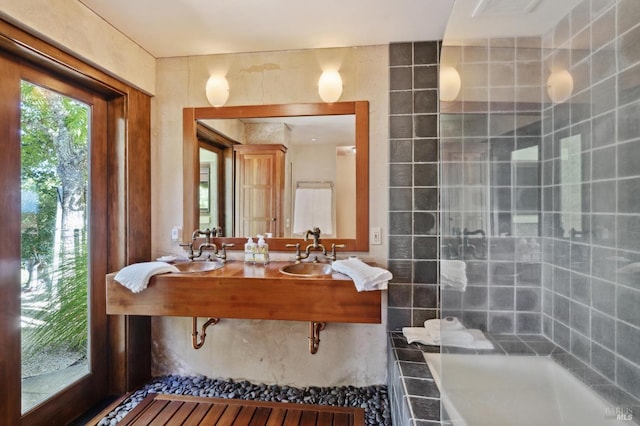 bathroom with a tile shower and a sink