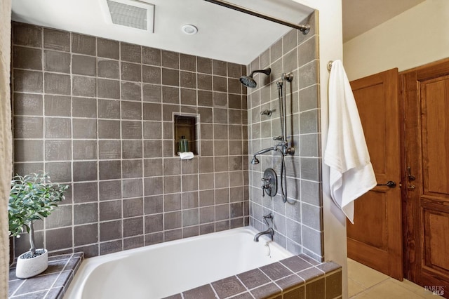 bathroom with tile patterned floors, visible vents, and tiled shower / bath