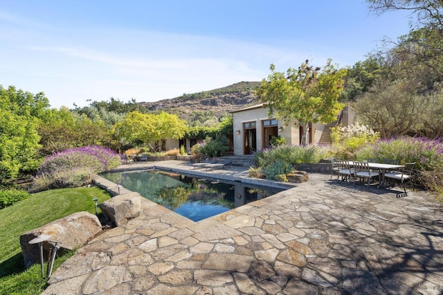 outdoor pool with outdoor dining space and a patio area