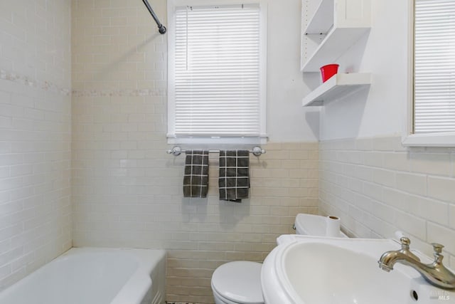 full bath featuring tile walls, toilet, a wainscoted wall, and a sink