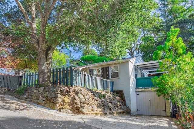 view of front of property with stucco siding, fence, and a balcony