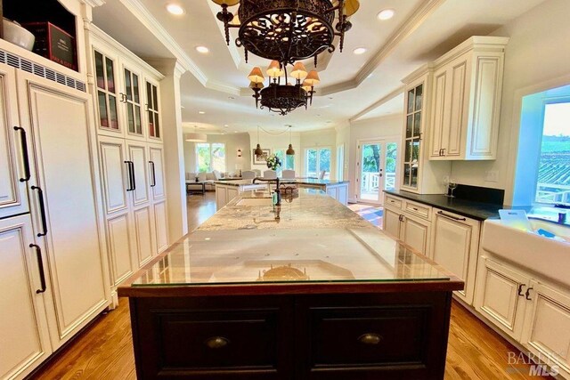kitchen with plenty of natural light, a kitchen island with sink, and an inviting chandelier