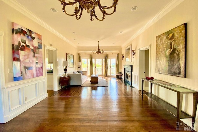 sitting room with crown molding, an inviting chandelier, and dark hardwood / wood-style floors