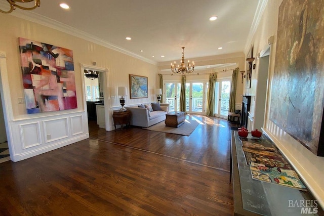 living room with an inviting chandelier, french doors, ornamental molding, and dark hardwood / wood-style flooring