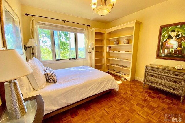 bedroom featuring parquet floors and a chandelier