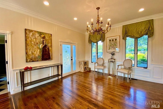 sitting room with crown molding, an inviting chandelier, and dark hardwood / wood-style floors