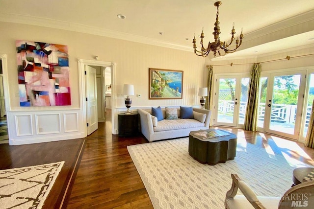 living room featuring crown molding, french doors, a chandelier, and dark hardwood / wood-style flooring
