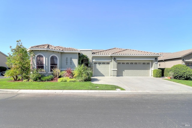 mediterranean / spanish-style house featuring a front lawn and a garage