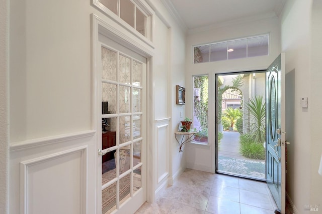 entryway featuring crown molding and light tile patterned flooring