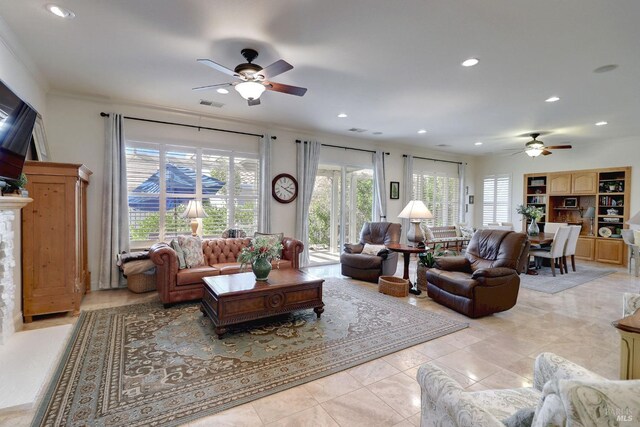 living room with crown molding, light tile patterned flooring, and ceiling fan