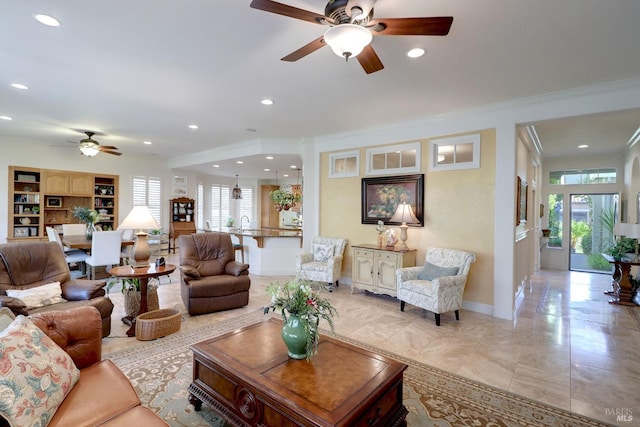 tiled living room with crown molding, ceiling fan, built in shelves, and a wealth of natural light