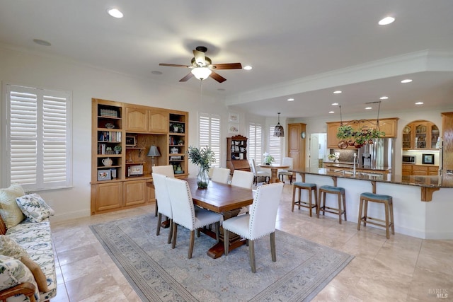 dining area with light tile patterned floors, crown molding, built in features, and ceiling fan