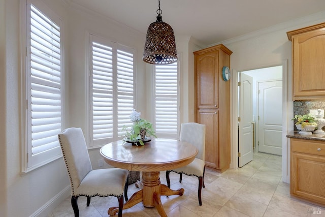 dining room featuring ornamental molding and baseboards