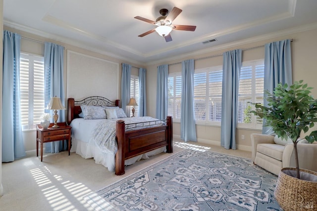 carpeted bedroom featuring crown molding, a tray ceiling, and ceiling fan