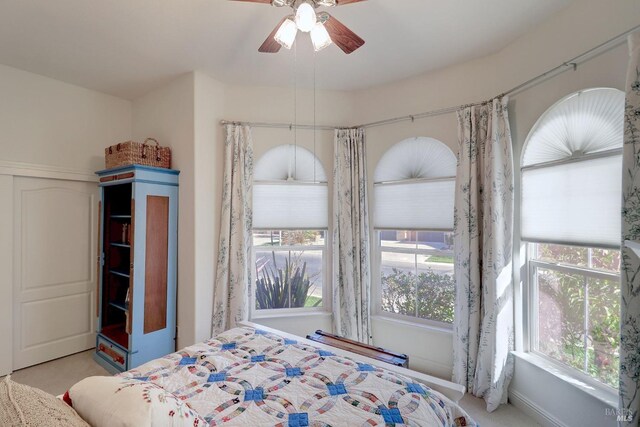 unfurnished bedroom with ceiling fan, multiple windows, and light colored carpet