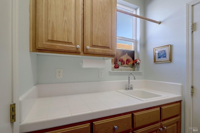 kitchen featuring tile countertops and sink