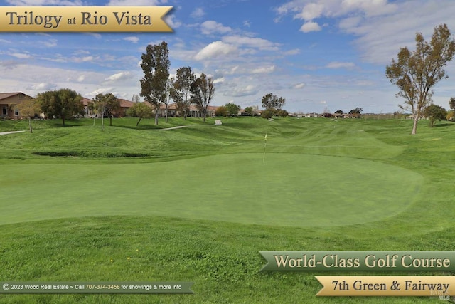 surrounding community featuring view of golf course and a yard