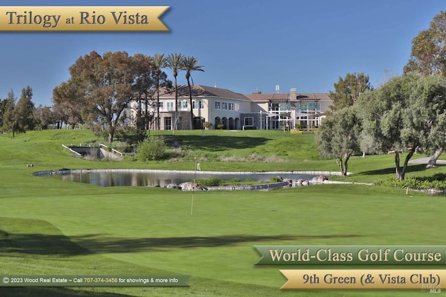 surrounding community with a water view, view of golf course, and a lawn