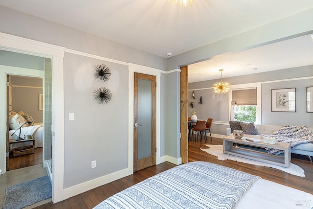 bedroom with an inviting chandelier and dark hardwood / wood-style flooring