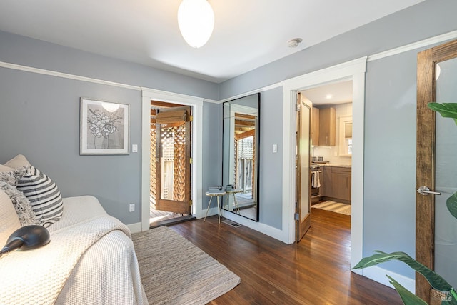 bedroom featuring ensuite bath, a closet, and dark hardwood / wood-style floors