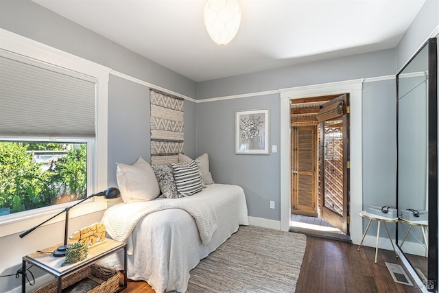 bedroom with dark hardwood / wood-style floors