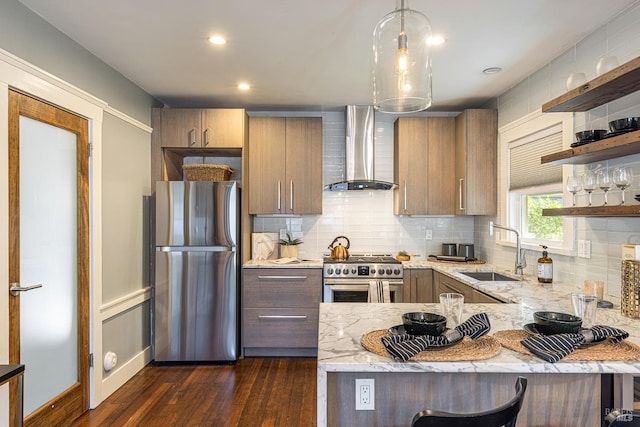 kitchen featuring sink, wall chimney exhaust hood, stainless steel appliances, a breakfast bar area, and dark hardwood / wood-style flooring