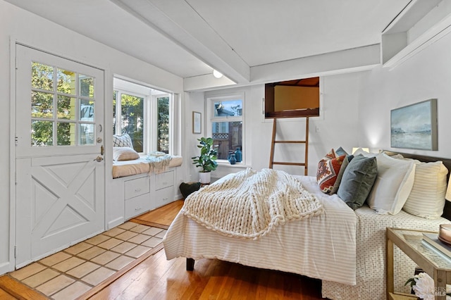 bedroom with beam ceiling and light hardwood / wood-style floors