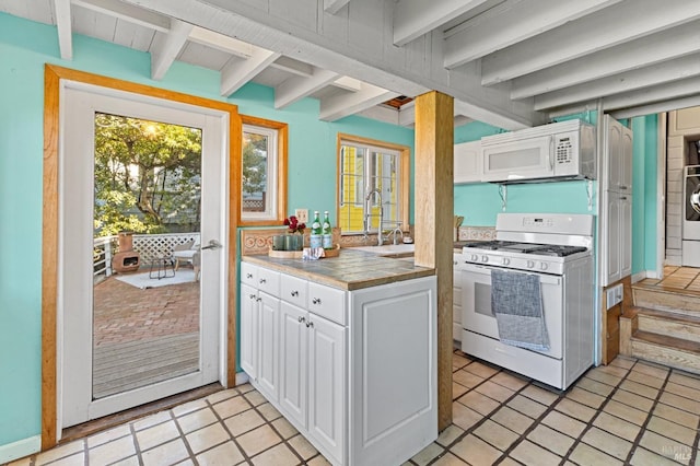 kitchen featuring white appliances, beam ceiling, sink, and white cabinets