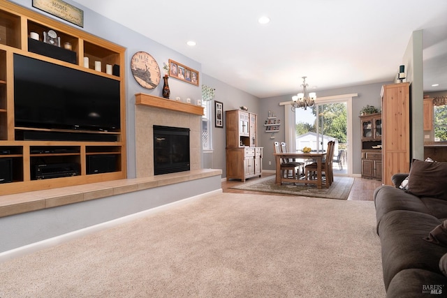 carpeted living room with an inviting chandelier and a tile fireplace