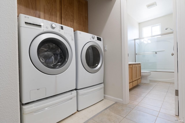 laundry room with light tile patterned flooring and washer and dryer