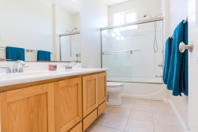 full bathroom featuring tile patterned floors, shower / bath combination with glass door, toilet, and vanity