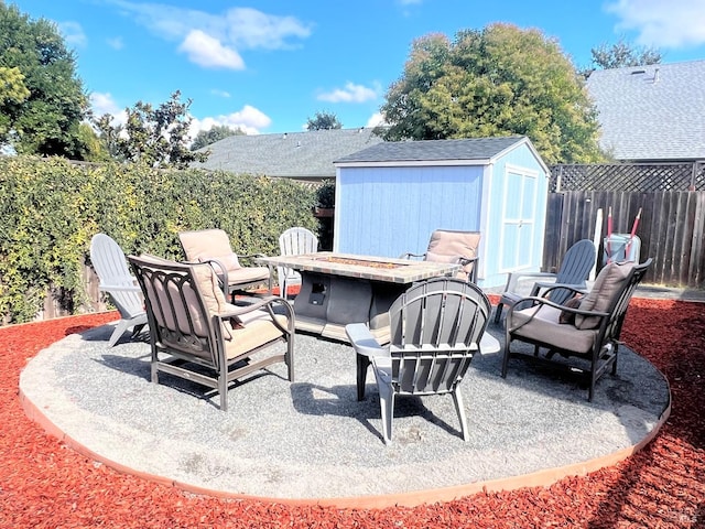 view of patio / terrace featuring a storage shed and an outdoor fire pit