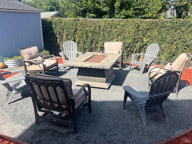 view of patio / terrace featuring a storage shed and a fire pit