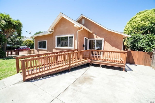 back of property with a deck and a patio area