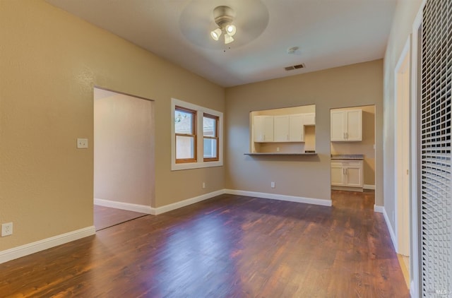 unfurnished living room featuring ceiling fan and dark hardwood / wood-style flooring