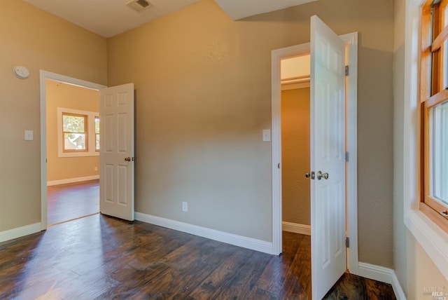 unfurnished bedroom featuring a closet and dark wood-type flooring