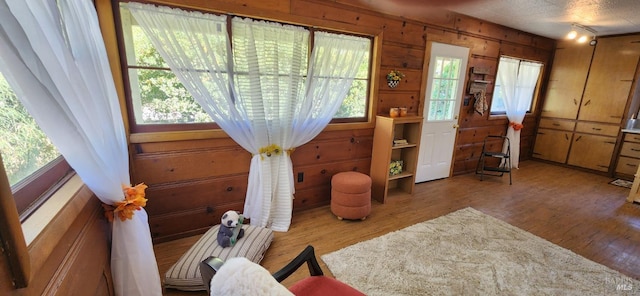 sitting room with wood walls, hardwood / wood-style floors, and a wealth of natural light