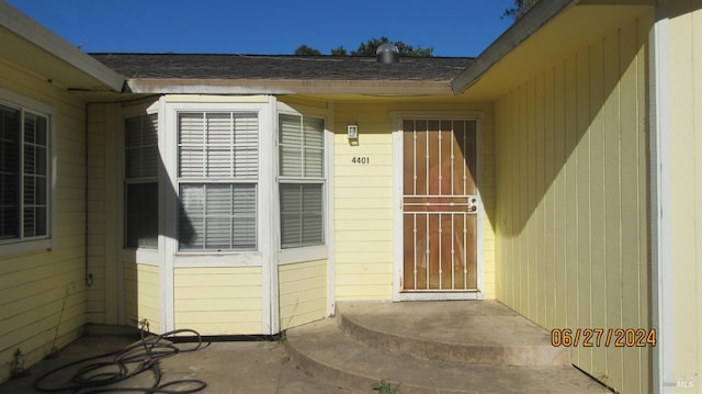 entrance to property with a shingled roof