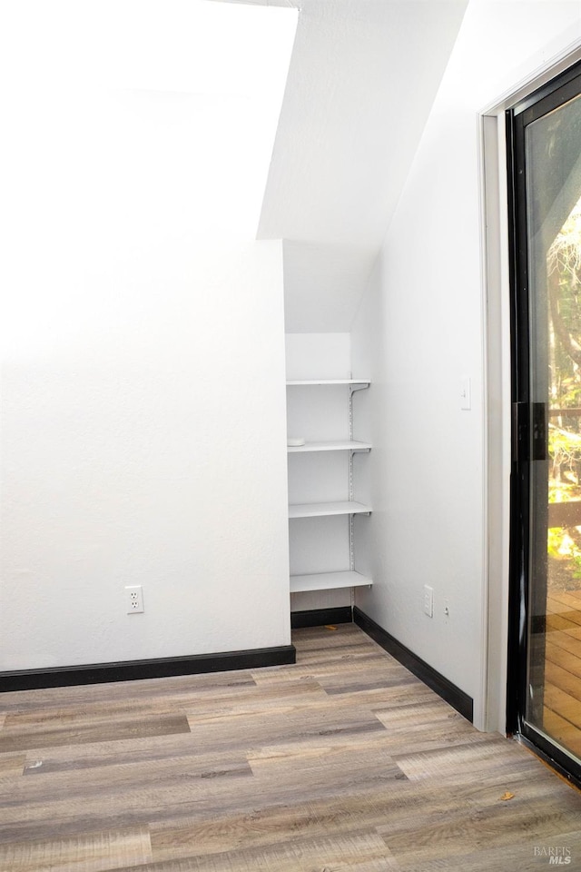 interior space featuring light hardwood / wood-style floors and lofted ceiling