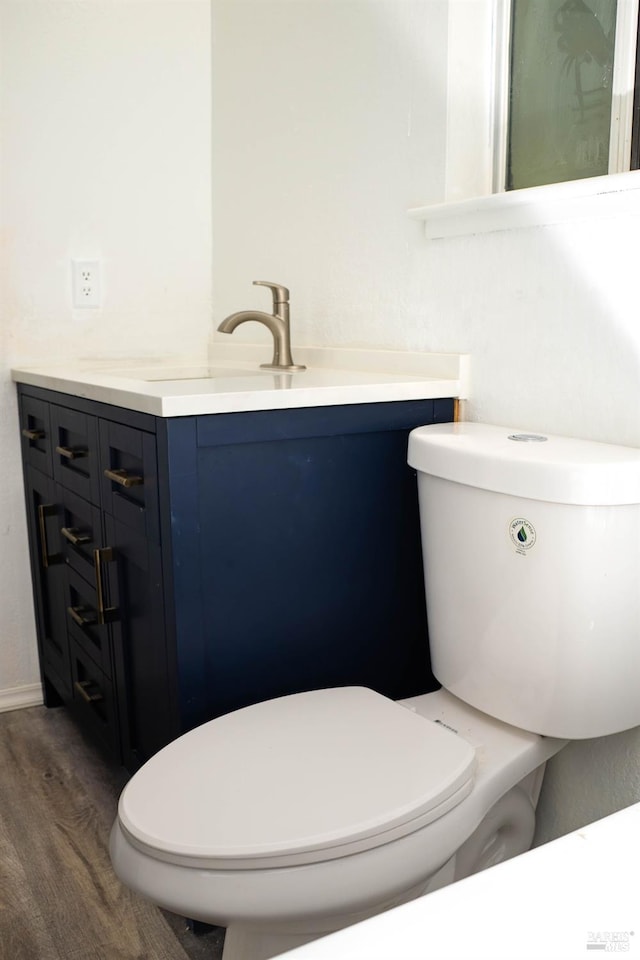 bathroom featuring toilet, vanity, and wood-type flooring