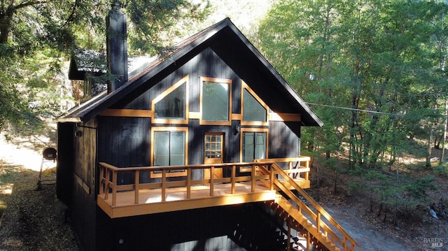 rear view of house featuring a wooden deck