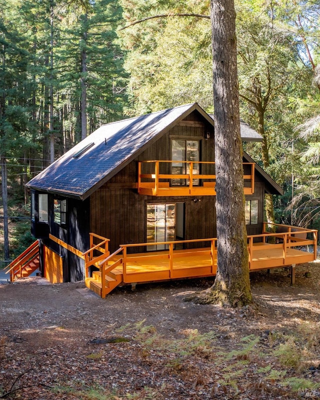 view of front of property featuring roof with shingles and a deck