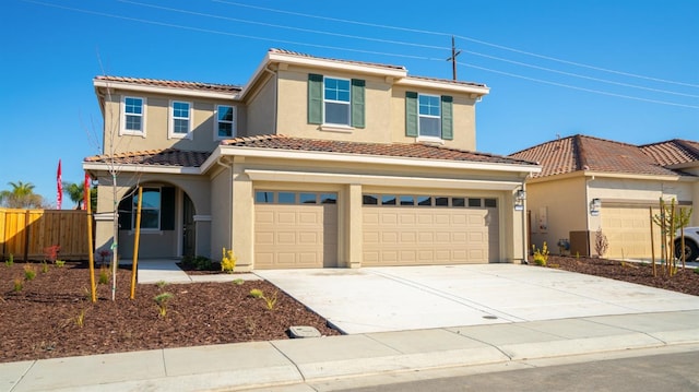 view of front of house with stucco siding, fence, concrete driveway, and a tile roof