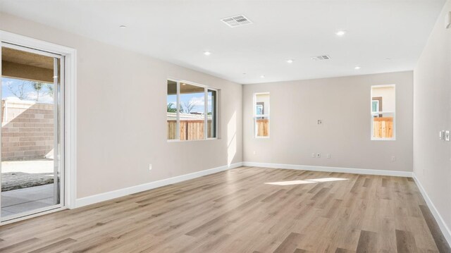 empty room featuring visible vents, recessed lighting, light wood-type flooring, and baseboards