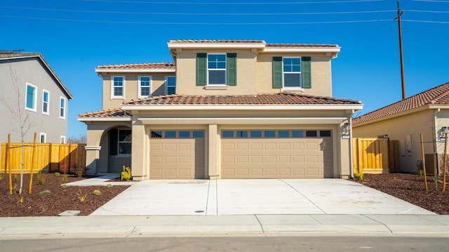 view of front of home featuring driveway, a tiled roof, fence, and an attached garage
