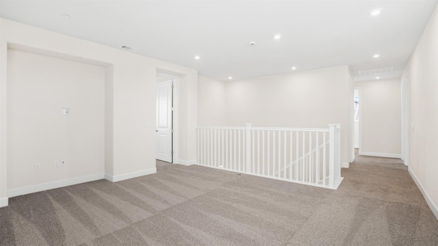 carpeted spare room featuring recessed lighting, visible vents, and baseboards