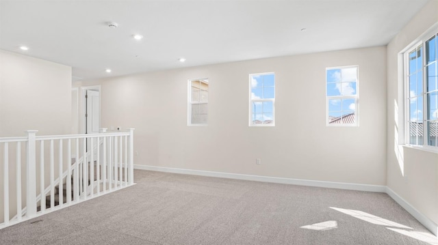 unfurnished room featuring carpet flooring, recessed lighting, a healthy amount of sunlight, and baseboards